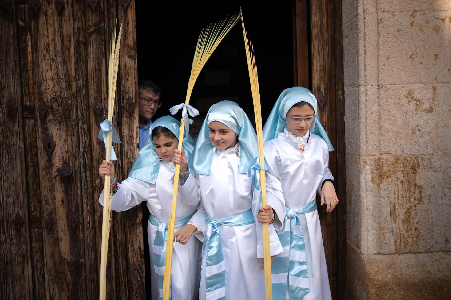 Tres niñas salen de la iglesia de San Cipriano antes de la procesión. Foto Emilio Fraile.