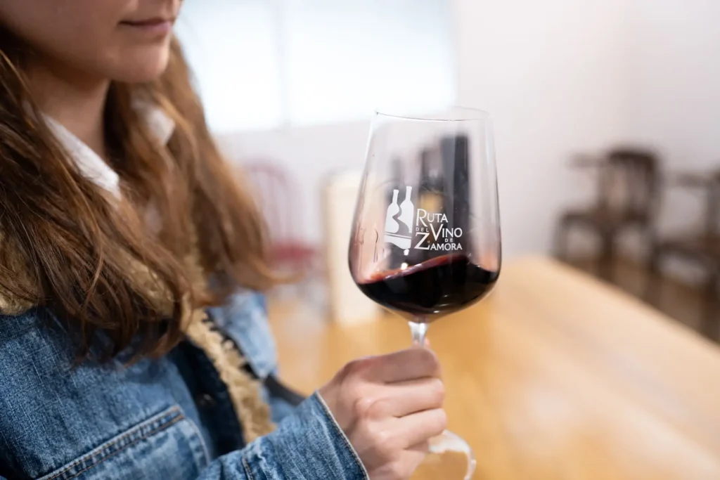 Una mujer bebe una copa de vino.