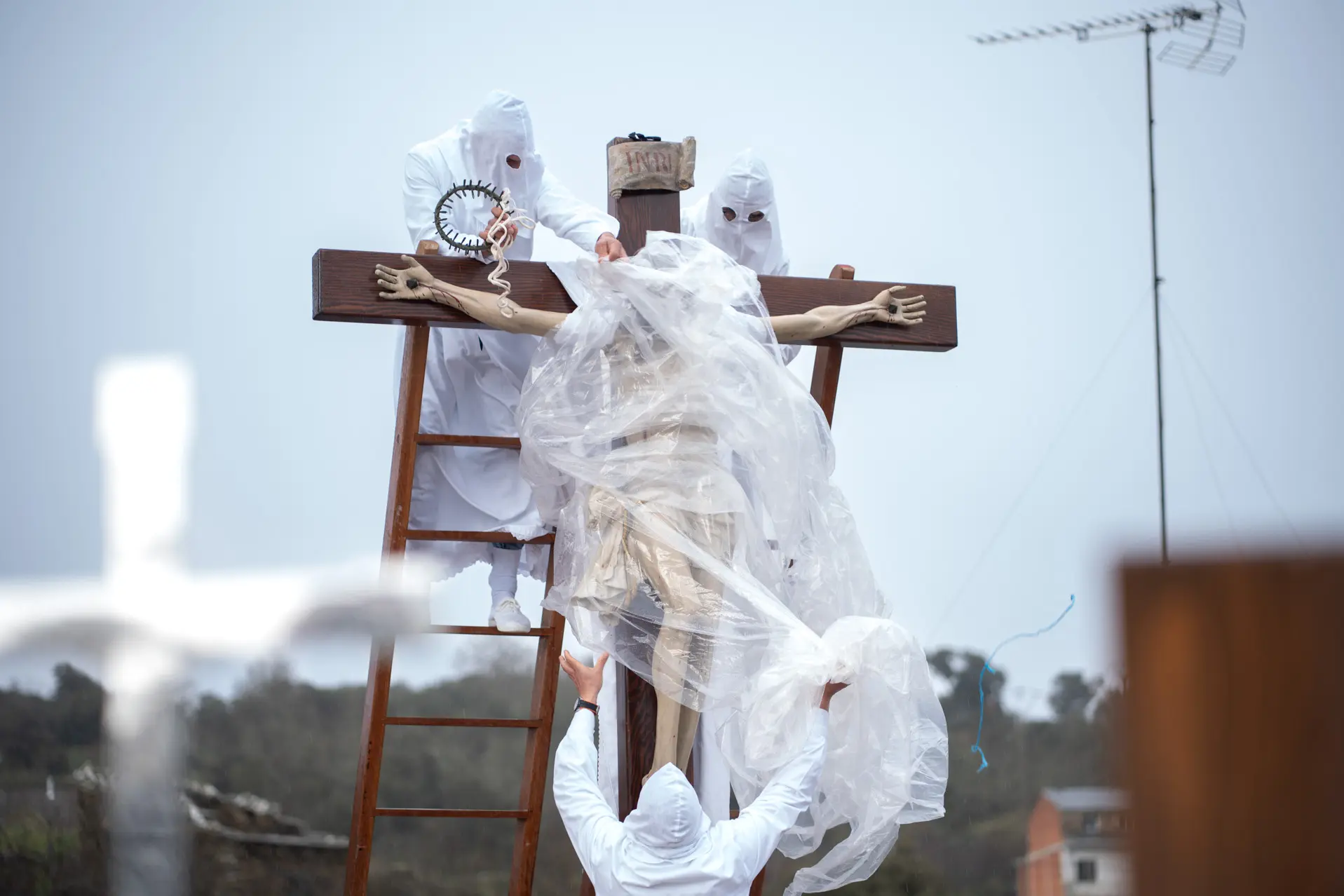 Dos hermanos retiran el plástico del Cristo de Bercianos. Foto Emilio Fraile.