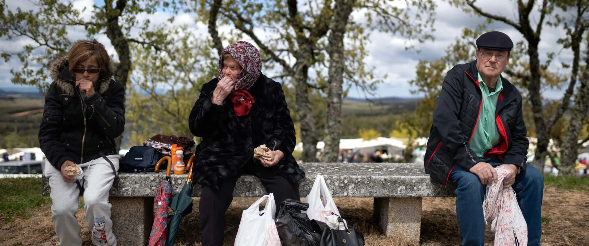 Tres personas, al pie del mercado en la romería de La Luz. Foto Emilio Fraile.