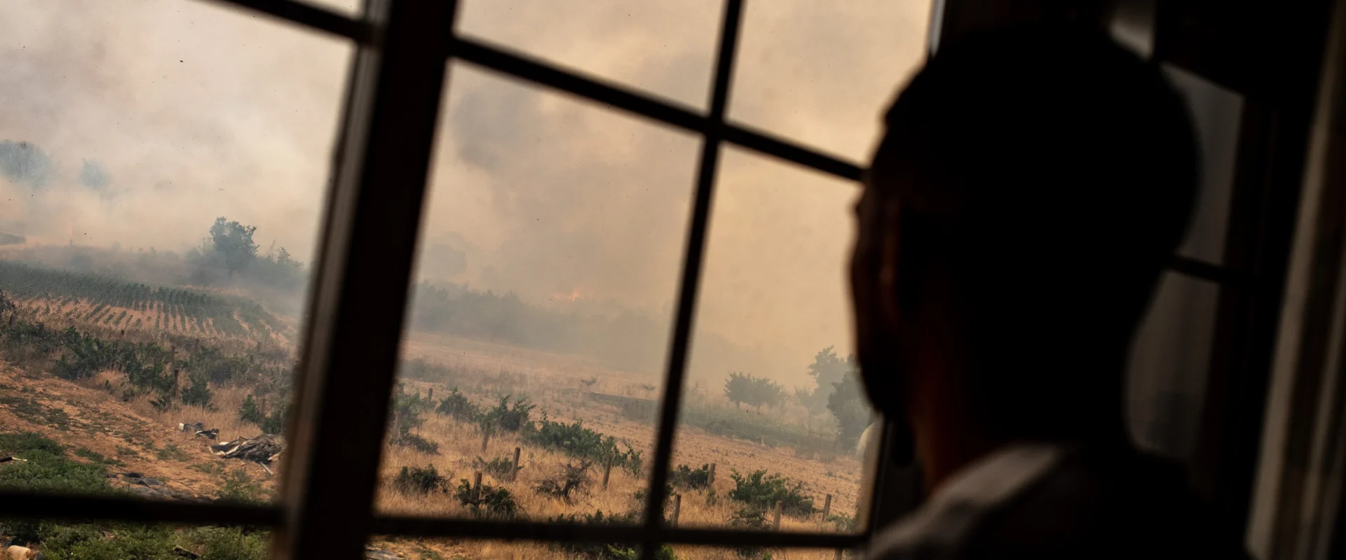 mira desde la ventana el fuego acercándose a su casa de Pumarejo de Tera. Foto Emilio Fraile.