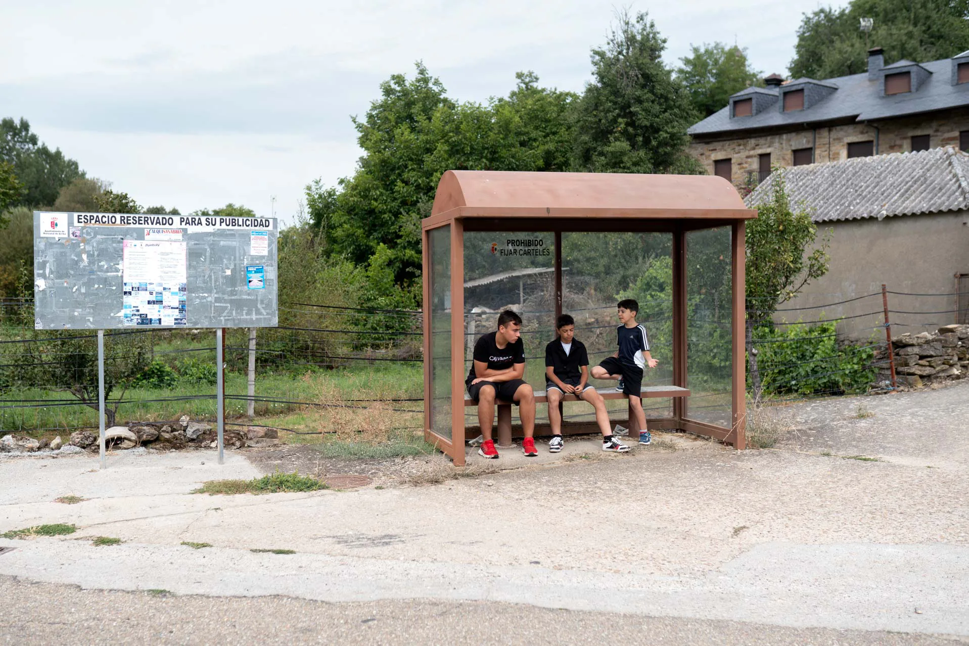 Los tres niños conversan en la parada del bus. Foto Emilio Fraile