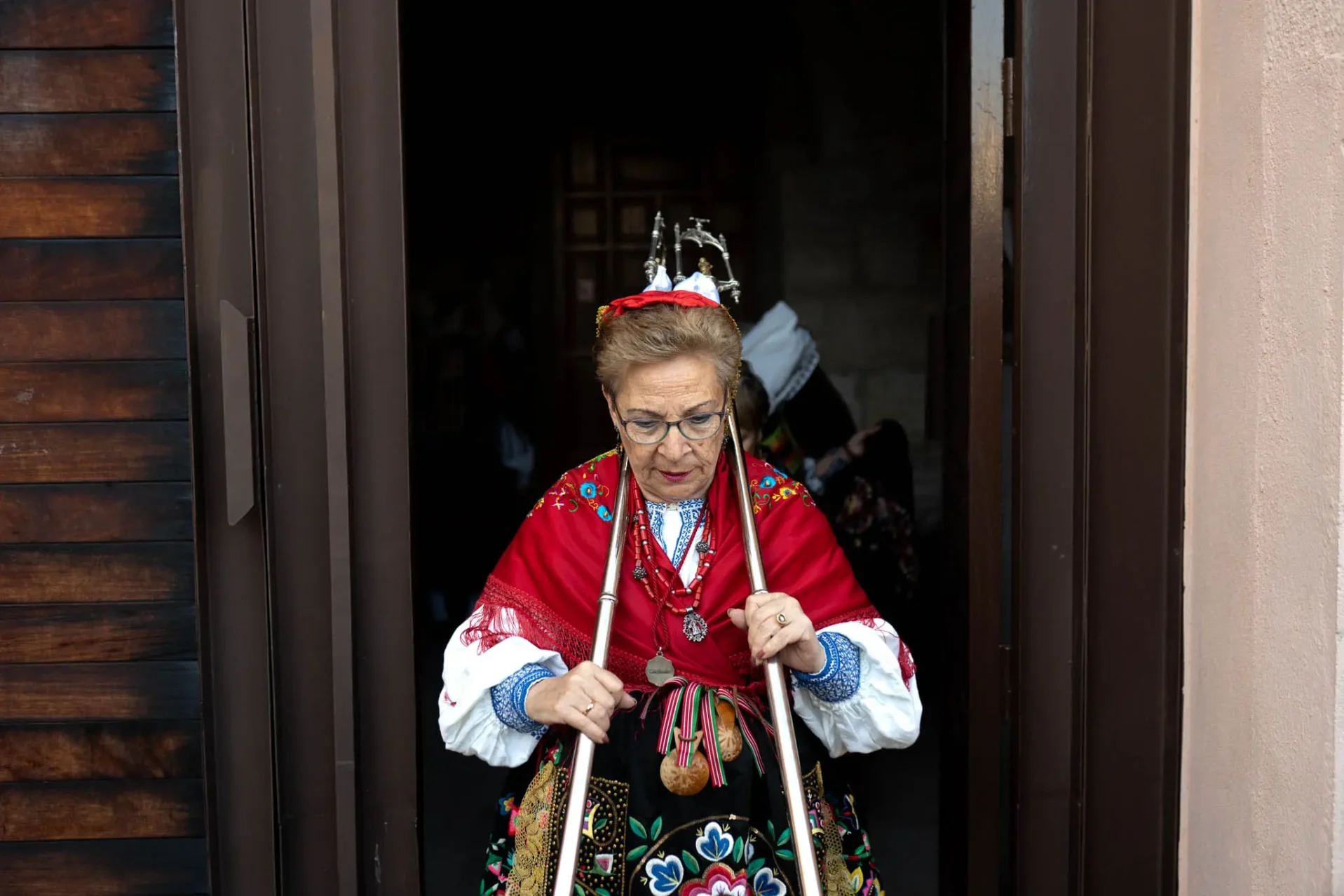 Una de las águedas sale de la iglesia portando las varas de las mayordomas. Foto Emilio Fraile.