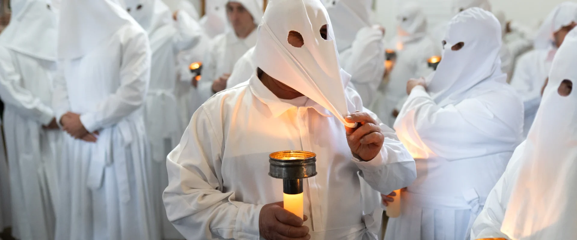Un penitente se coloca la capucha de la túnica. Foto Emilio Fraile.