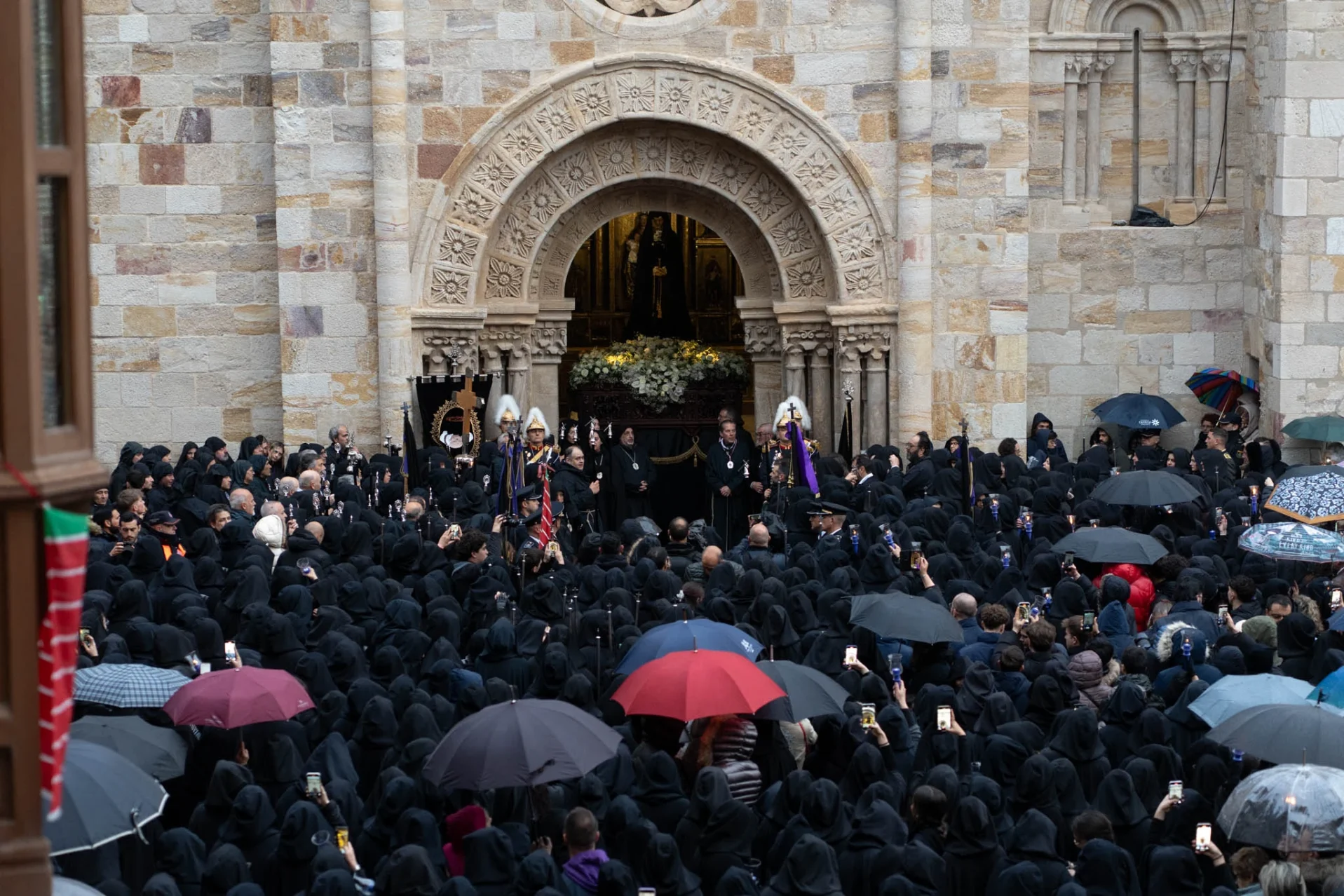 Las damas y los paraguas se agolpan frente a la puerta de San Juan para ver a la Virgen. Foto Emilio Fraile.