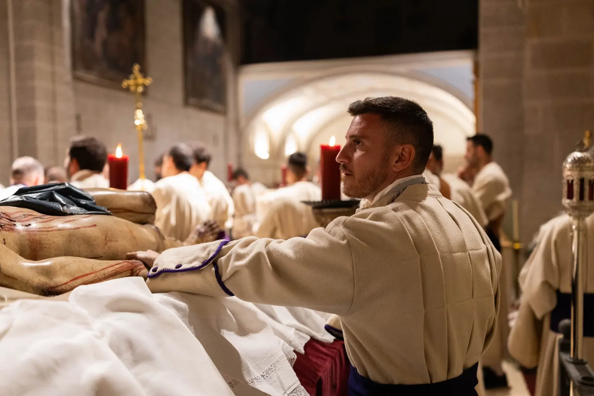 Un penitente reza al Cristo Yacente antes del desfile. Foto Emilio Fraile.